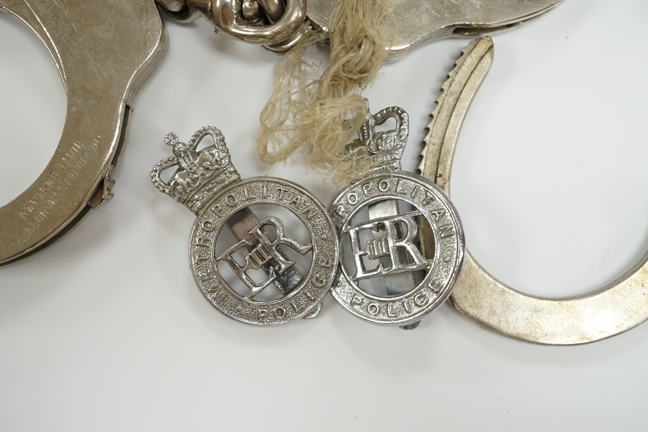 Three handcuffs, two with keys and two Metropolitan Police badges
